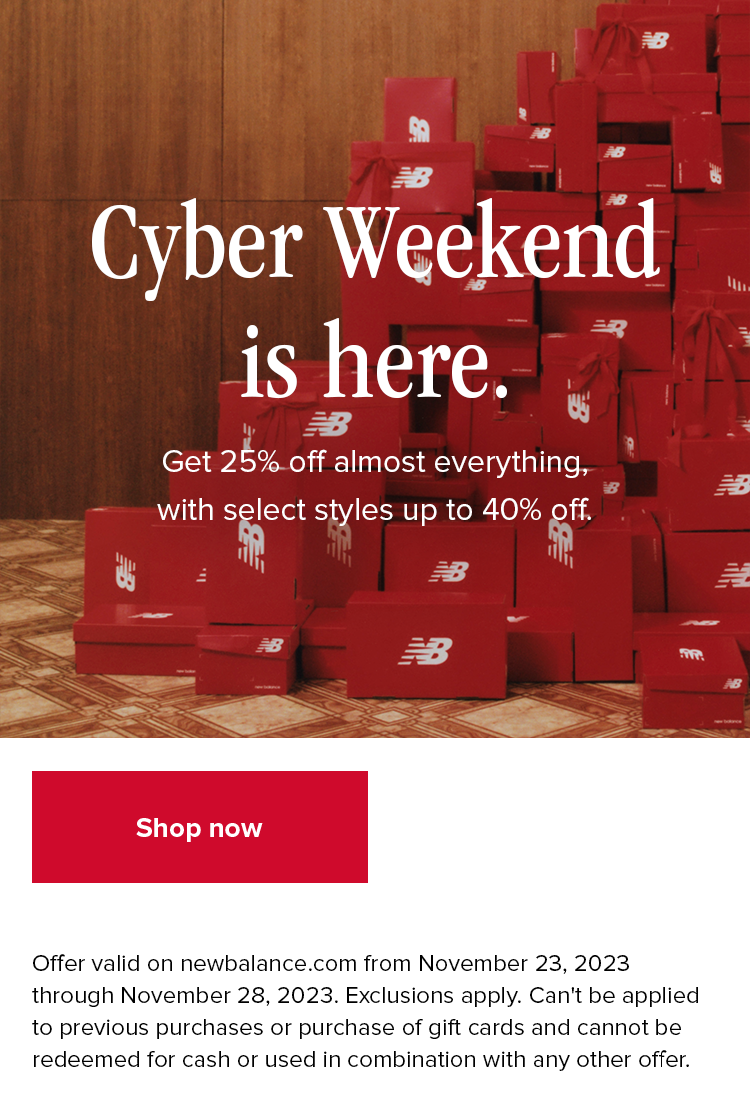 A large stack of red New Balance shoe boxes with red bows attached piled high against a wood panel wall